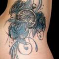 tatuaje Reloj Lado Flores por Belly Button Tattoo Shop