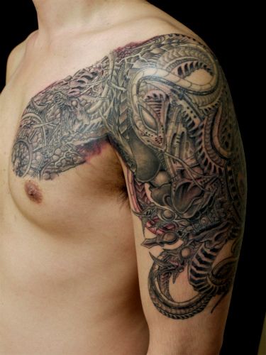 Tatuaggio Spalla Biomeccanici Petto di Wizdom Tattoo
