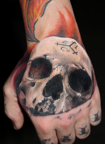 Tatuaje Cráneo Mano por Requiem Body Art