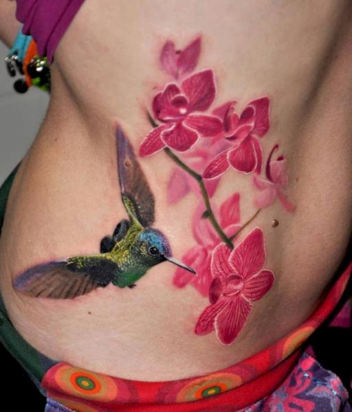 Tatuaje Realista Flor Lado Colibrí por Nadelwerk